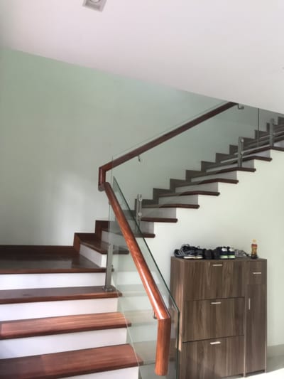 Cầu thang kính tay vịn gỗ tròn | Decohouse chuyên cầu thang tại Hà Nội